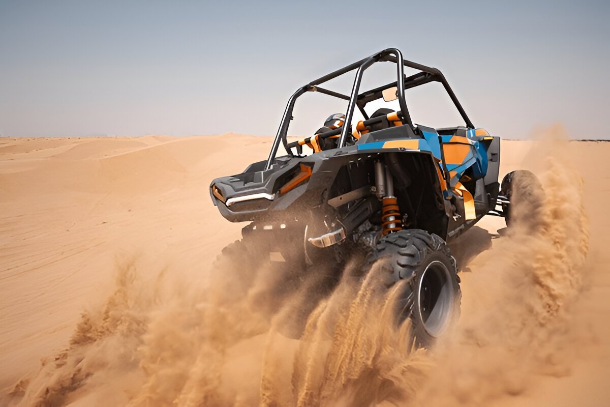 Action-packed scene of a buggy racing over towering sand dunes in Dubai, kicking up sand under a bright blue sky." @exploredesertsafari.com