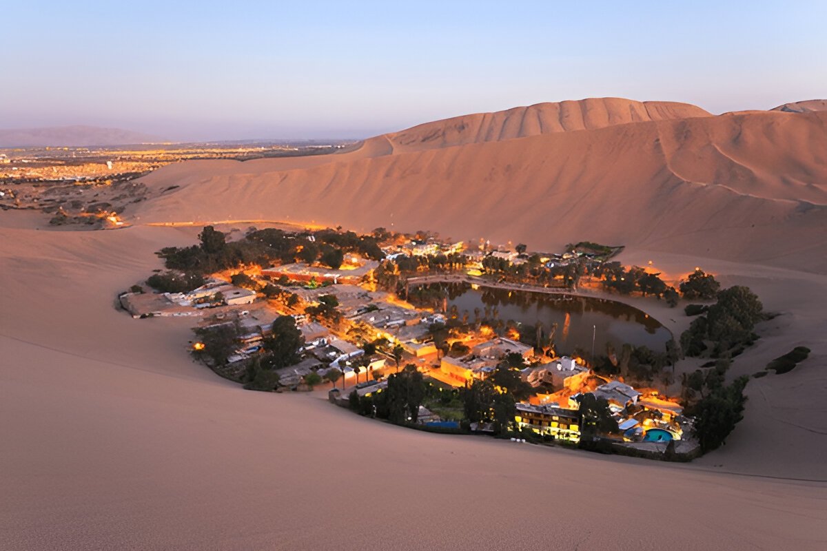 Luxurious desert camp at sunset with Arabian-style tent, glowing lanterns, and gourmet dining in the golden sand dunes. @exploredesertsafari.com