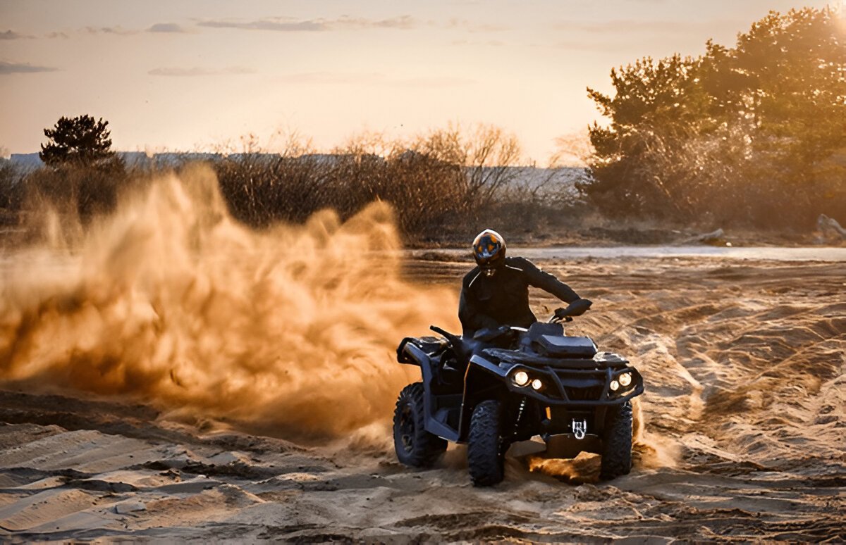 Action-packed scene of quad biking in the Dubai desert, with a rider speeding across golden sand dunes under a bright blue sky." @exploredesertsafari.com